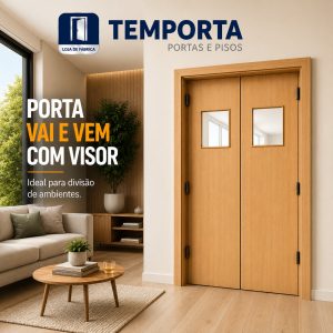 Porta vai e vem dupla em madeira com visor quadrado, instalada em ambiente interno moderno e sofisticado. A porta possui acabamento amadeirado claro, duas folhas com janelas de vidro centralizadas e ferragens pretas. Ao lado, há uma sala de estar aconchegante com sofá, mesa de centro, tapete e decoração em tons naturais, destacando a funcionalidade da porta para divisão de ambientes residenciais e comerciais.